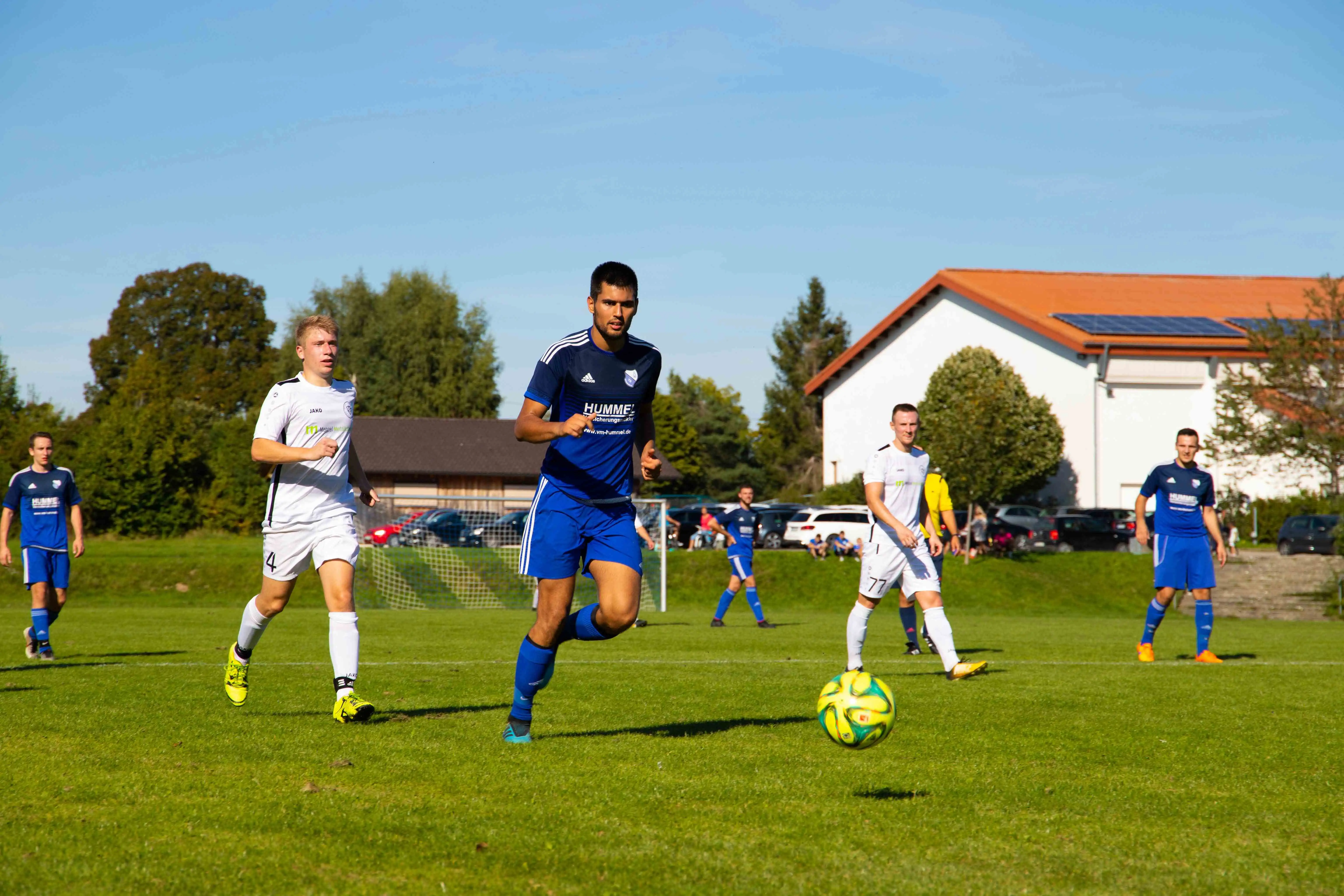 To mænd der løber efter en fodbold under en udendørs fodboldkamp